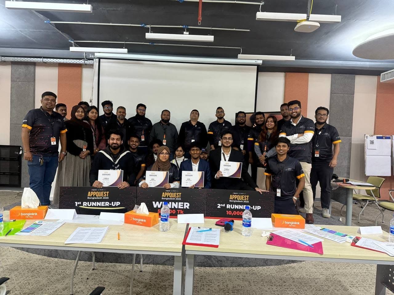 Finalists and organisers of AppQuest Bangladesh 2025 holding certificates behind Winner and Runner-up placards