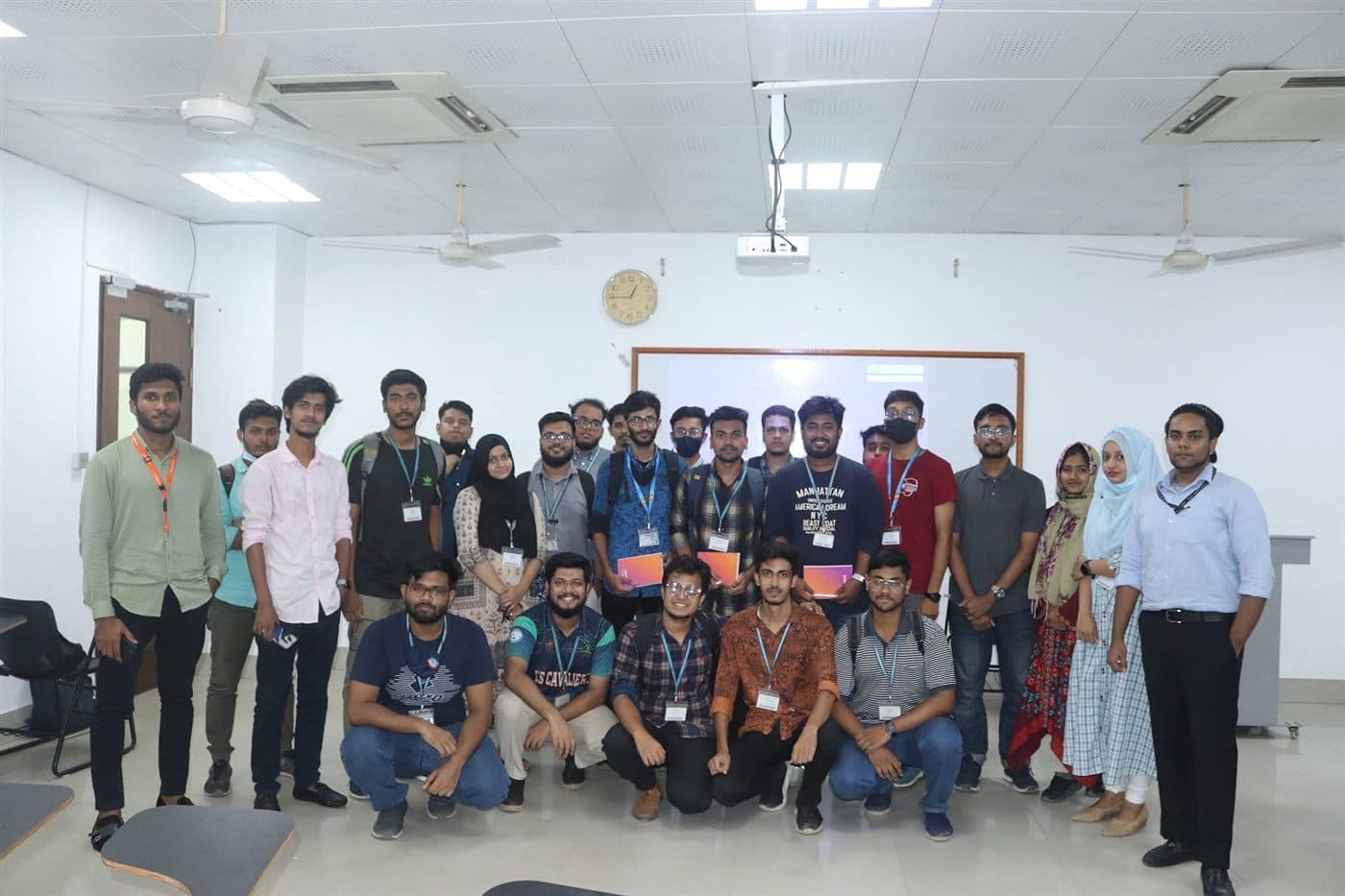 A group of students and organisers with lanyards after a campus workshop