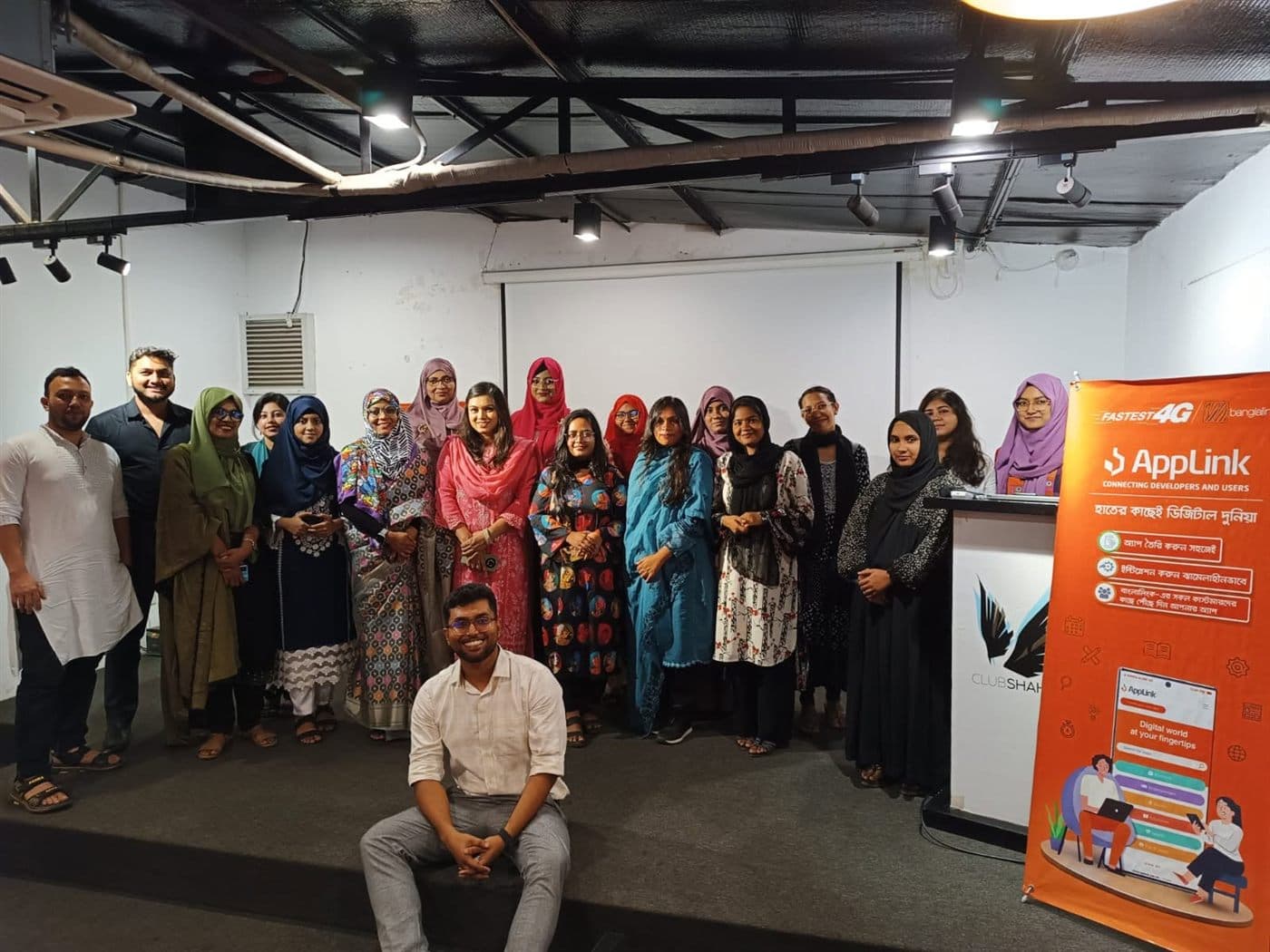 Attendees at an AppLink community meetup standing beside an AppLink banner