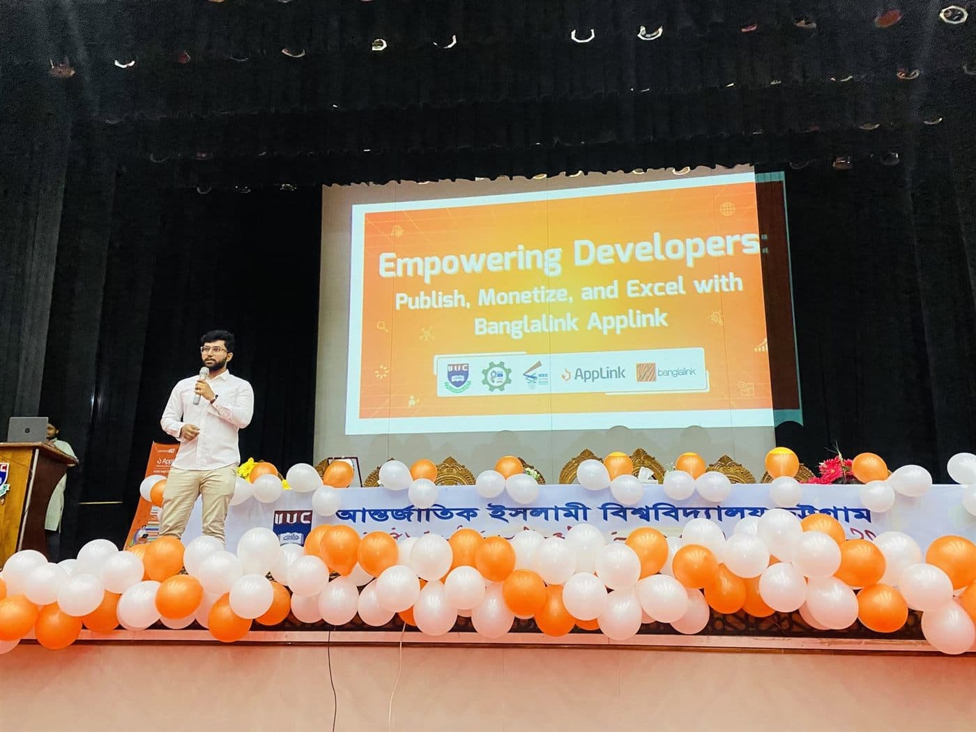 A speaker on stage at International Islamic University Chittagong beside a slide reading Empowering Developers