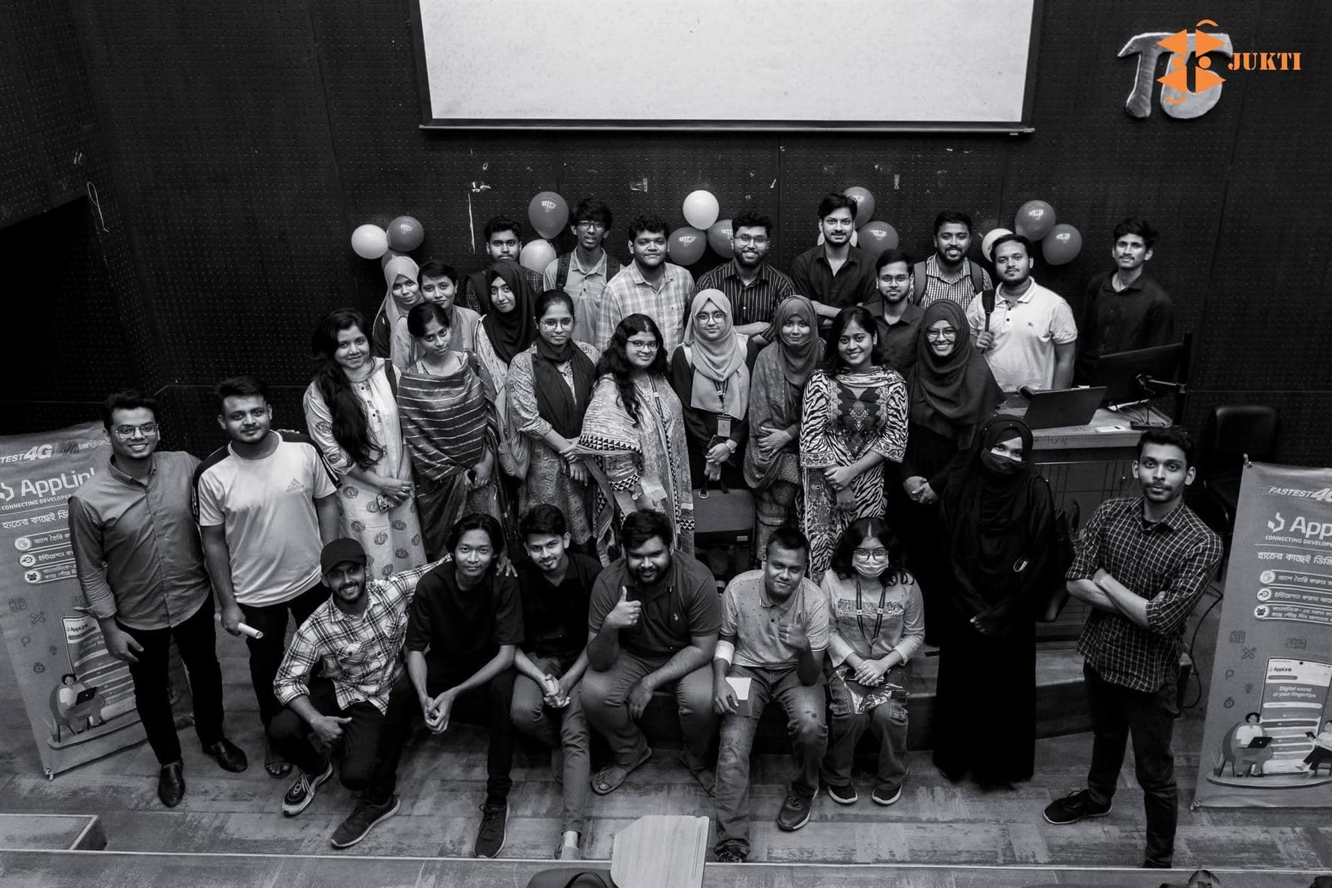 A large group of AppLink community members gathered on stage between two AppLink banners
